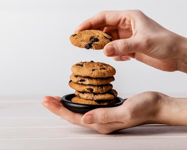 Close-up of a hand reaching for a freshly baked triple-chip cookie slab