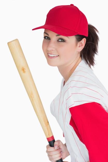 woman smiling and holding a softball bat