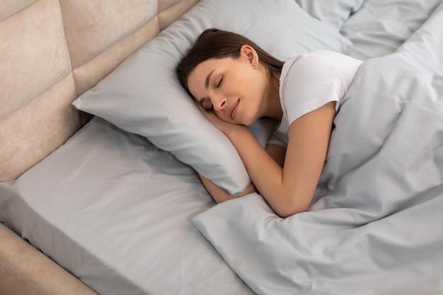 woman peacefully sleeping in comfortable bed