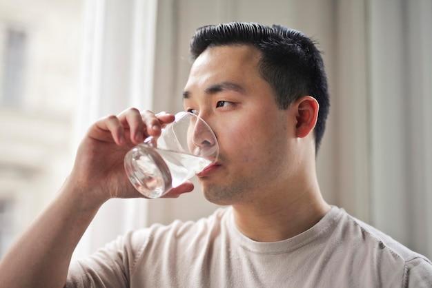 person drinking a large glass of water