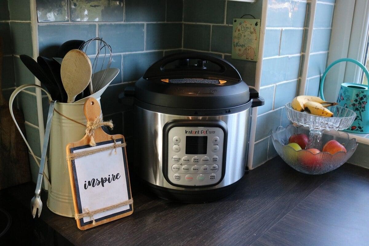 A close up shot of the Instant Pot Duo on a kitchen counter with steam rising from it