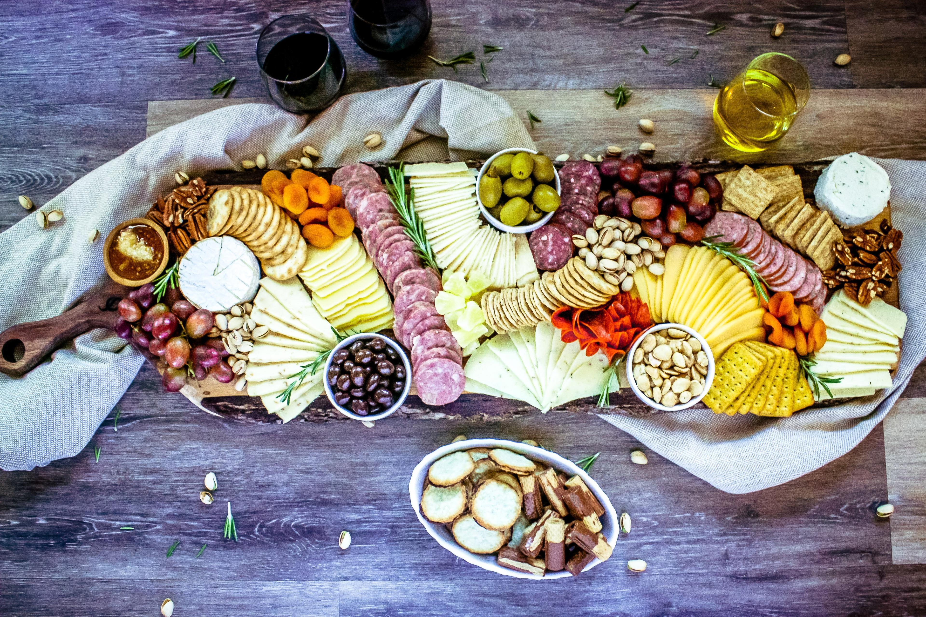 A variety of fresh vegetables and cheeses laid out beside a baking dish for customization