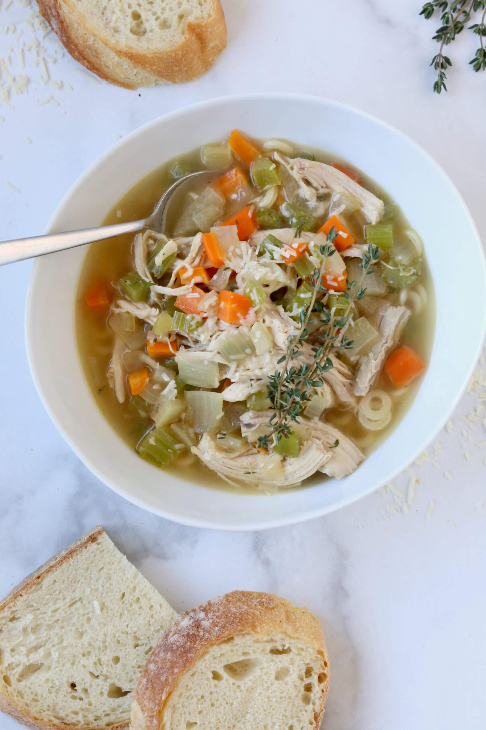 Chef smiling while tasting homemade chicken noodle soup