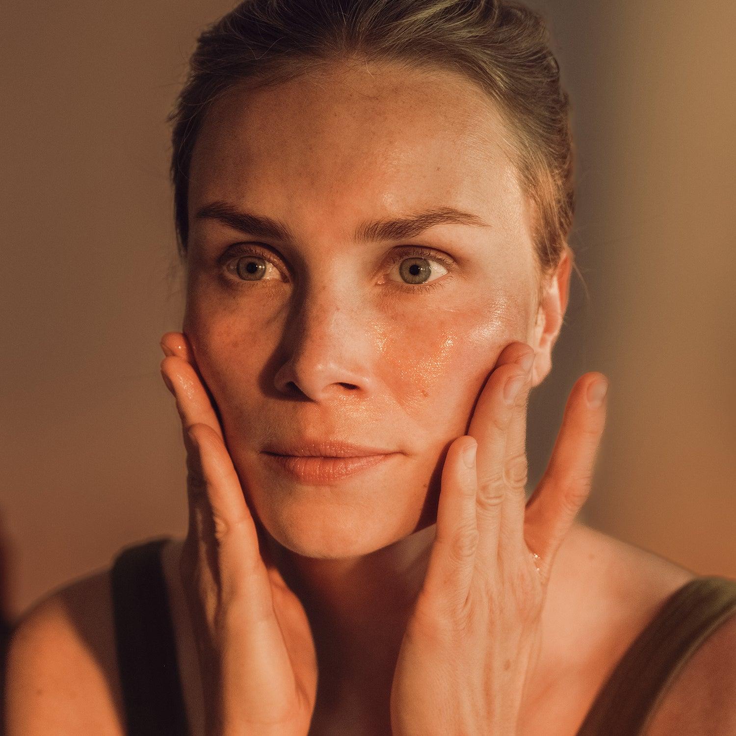 close-up of oil cleanser being applied to face