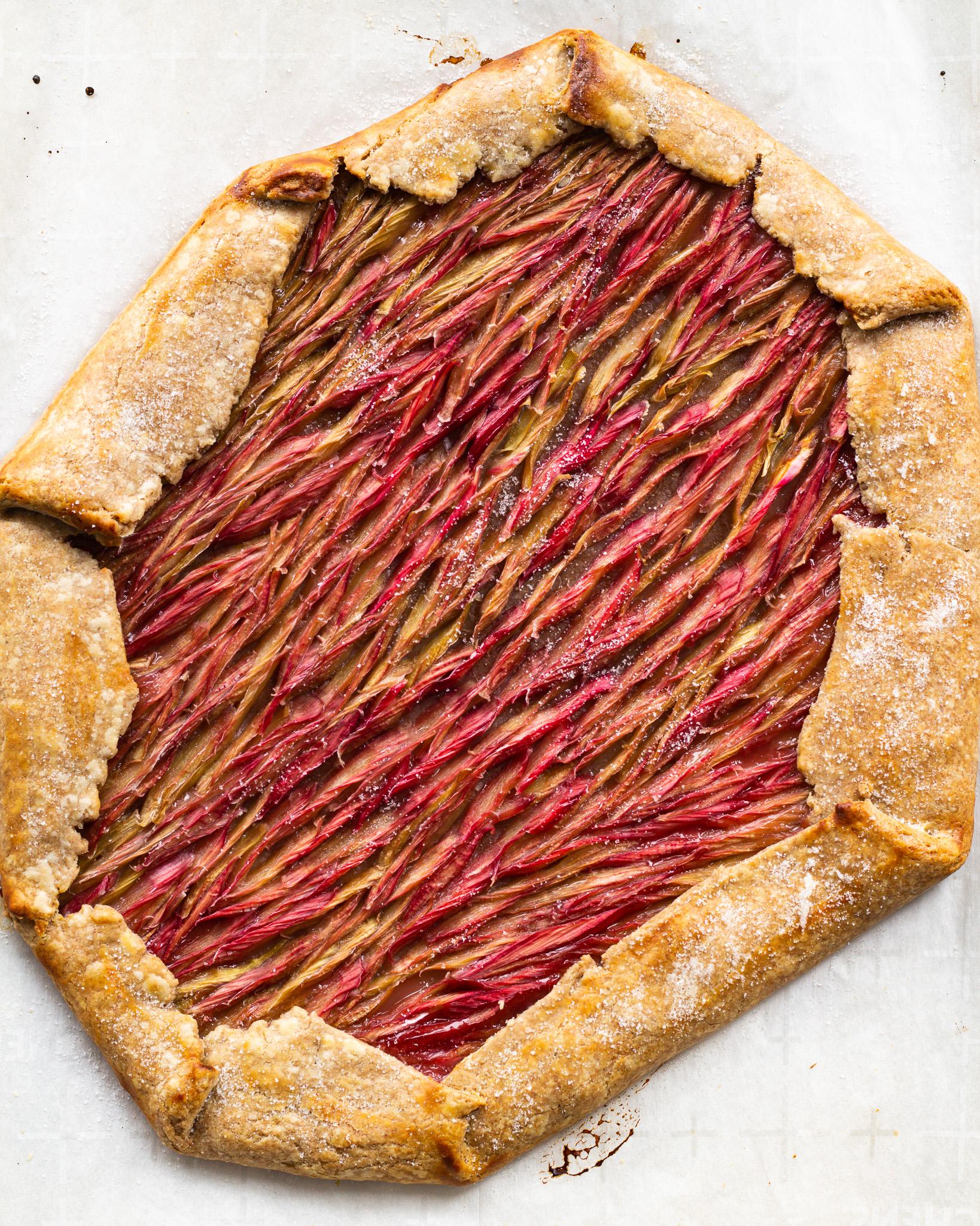 A person slicing the Rhubarb Ginger Virgin Mojito Tart, showing the filling and crust