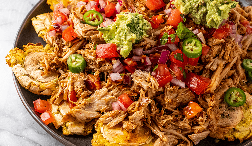 Overhead shot of Spiced Rum Pulled Pork with Plantain Chips, plated and ready to serve