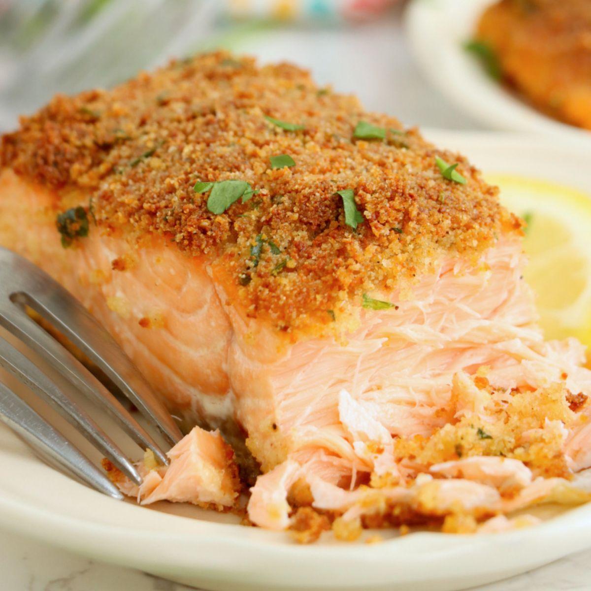 close-up of golden brown herb crust on baked salmon, showing texture and fresh herbs