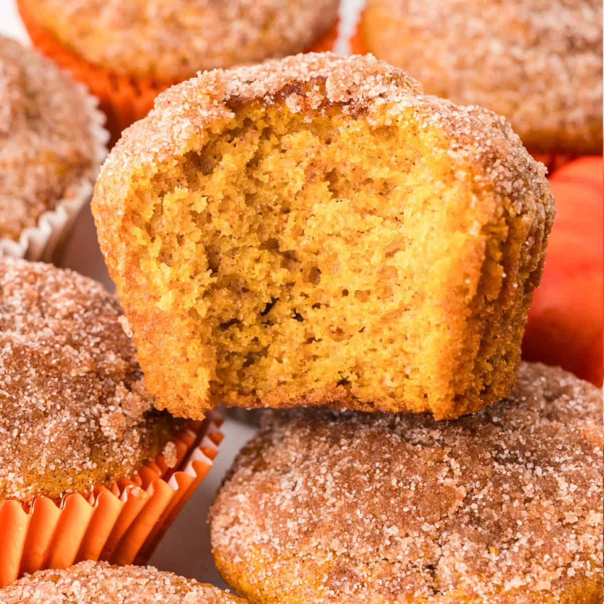 child helping to sprinkle cinnamon on top of pumpkin spice muffins before baking