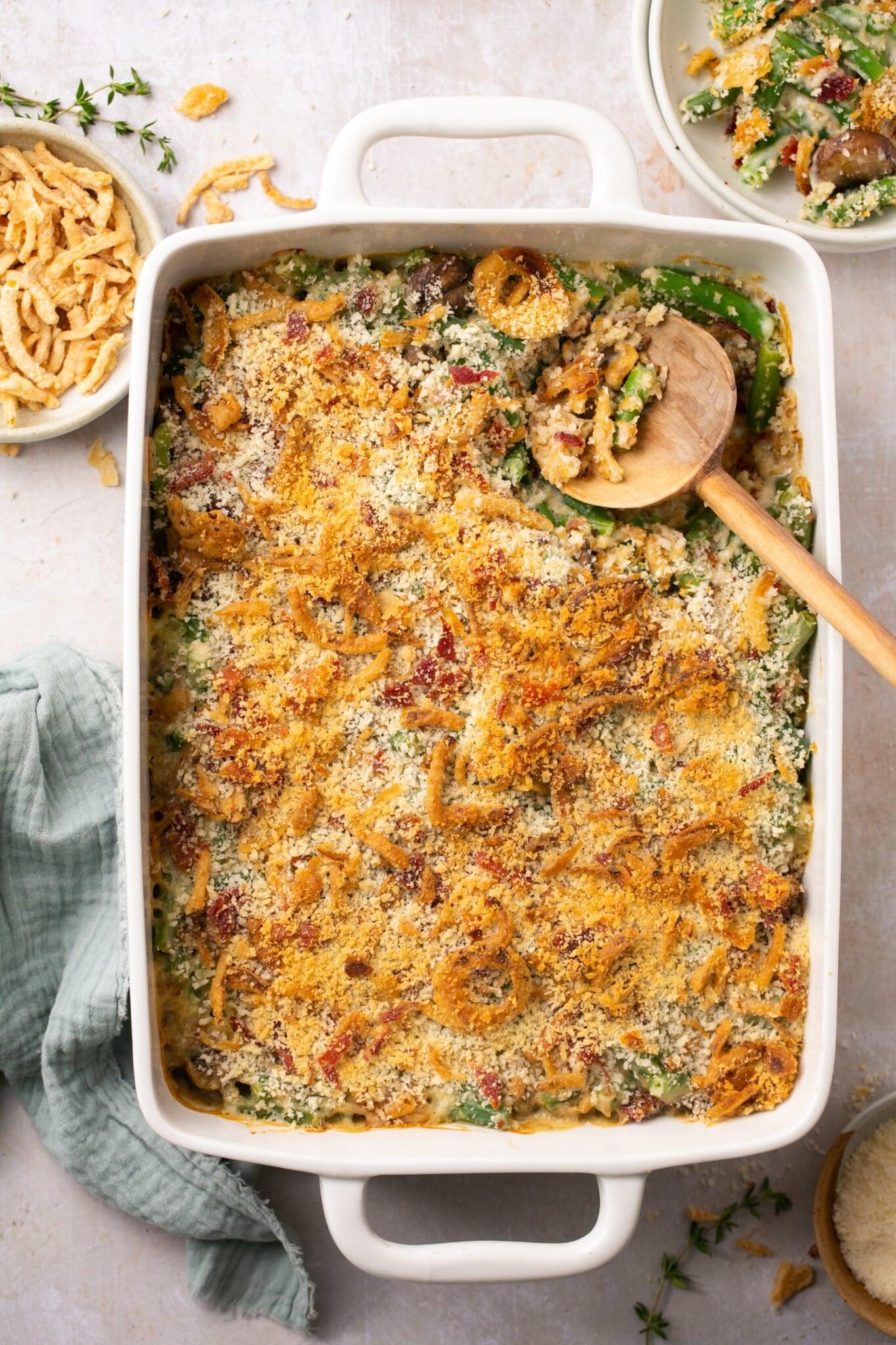 Homemade green bean casserole with golden crispy onion topping, family style, warm lighting