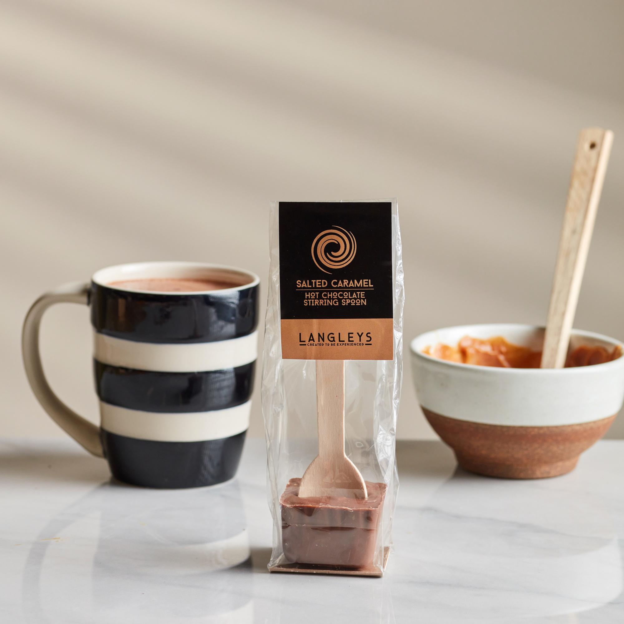 close up of rich, dark hot chocolate being stirred with a spoon, showing a caramel swirl