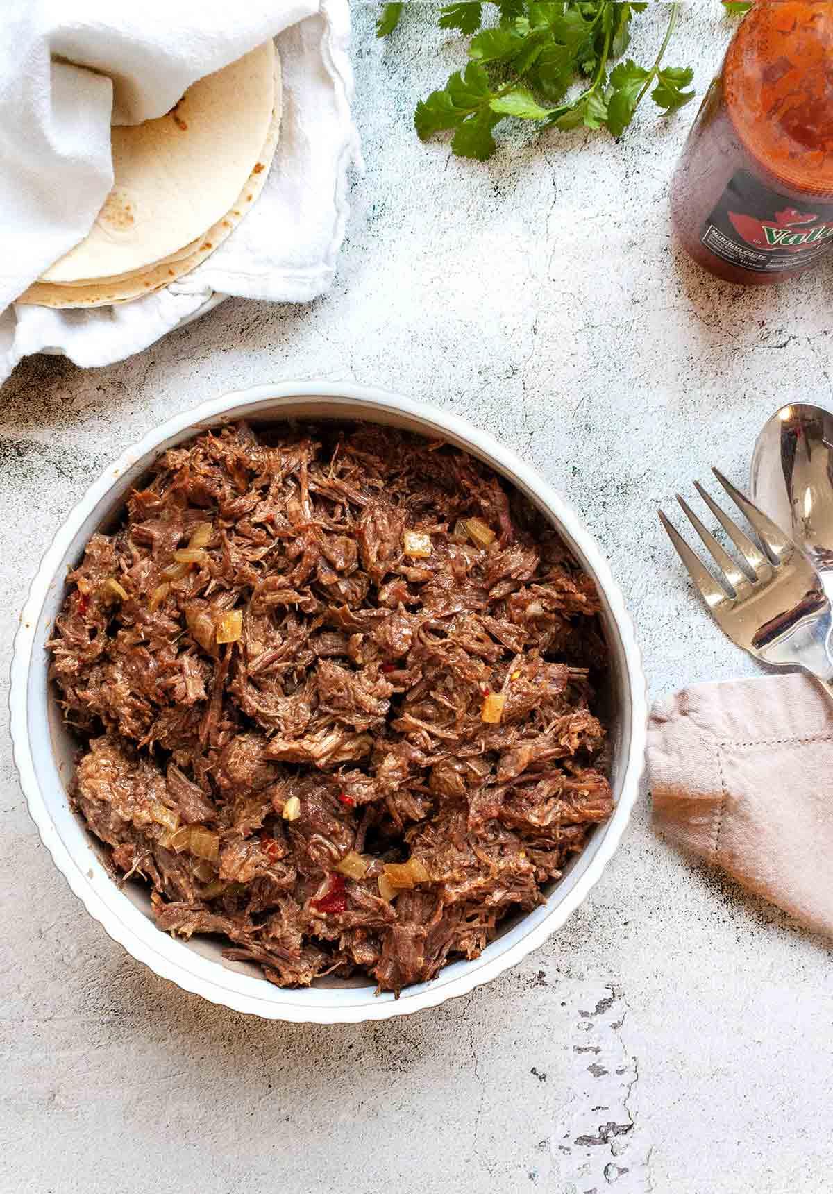Close-up of shredded chili beef roast on a fork, steam rising