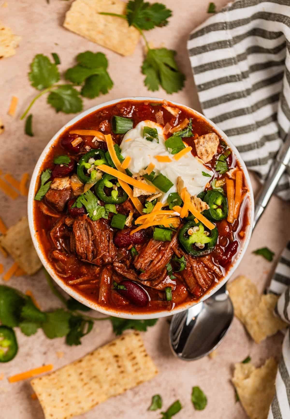 Close-up of a slow-cooked chili-pepper beef roast, tender and juicy, garnished with fresh cilantro, steam rising, comfort food photography