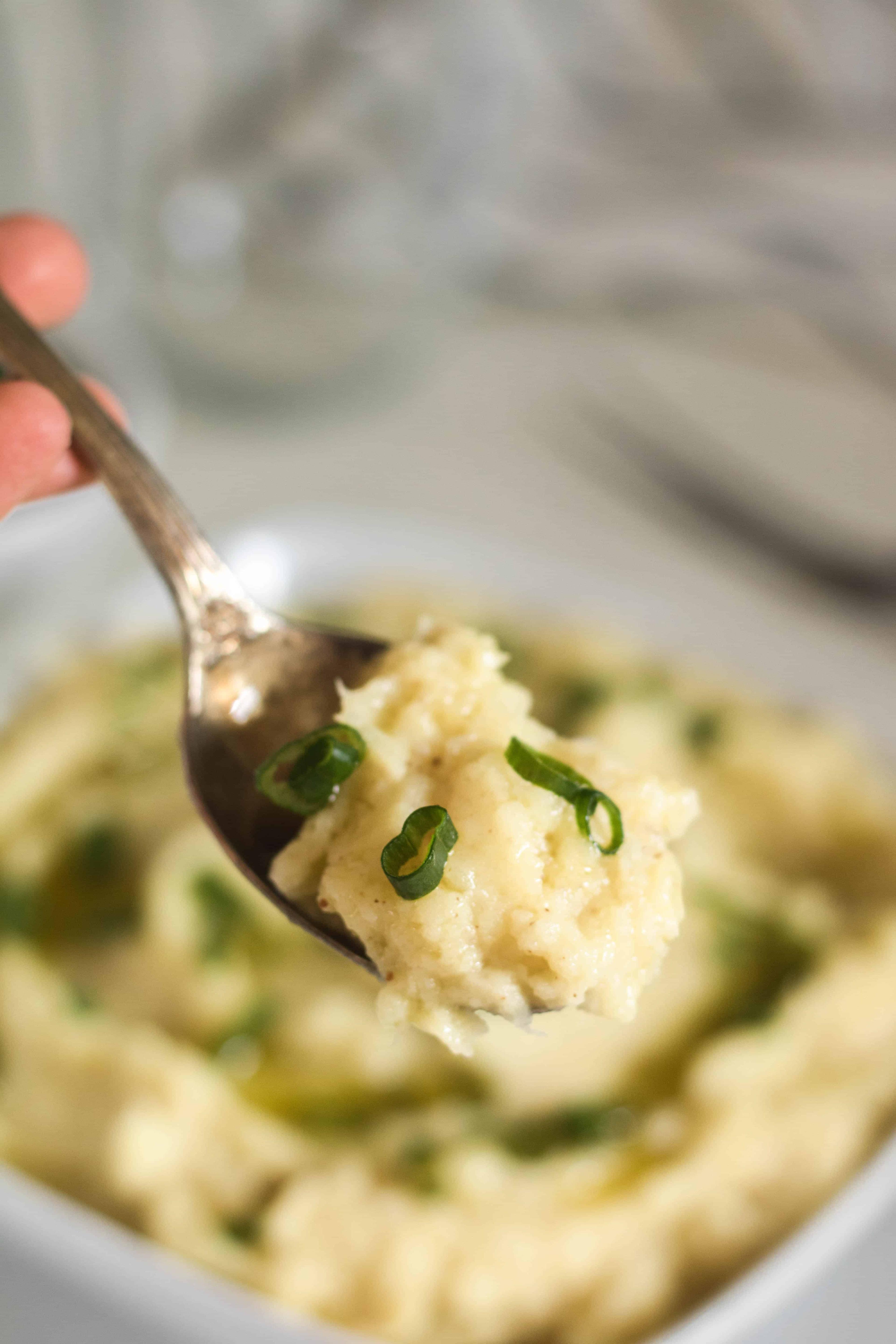 close-up of brown butter sweet potato mash in a white bowl with a spoon