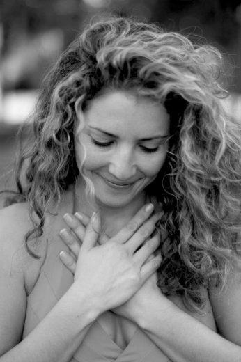 woman comforting herself, hand on heart