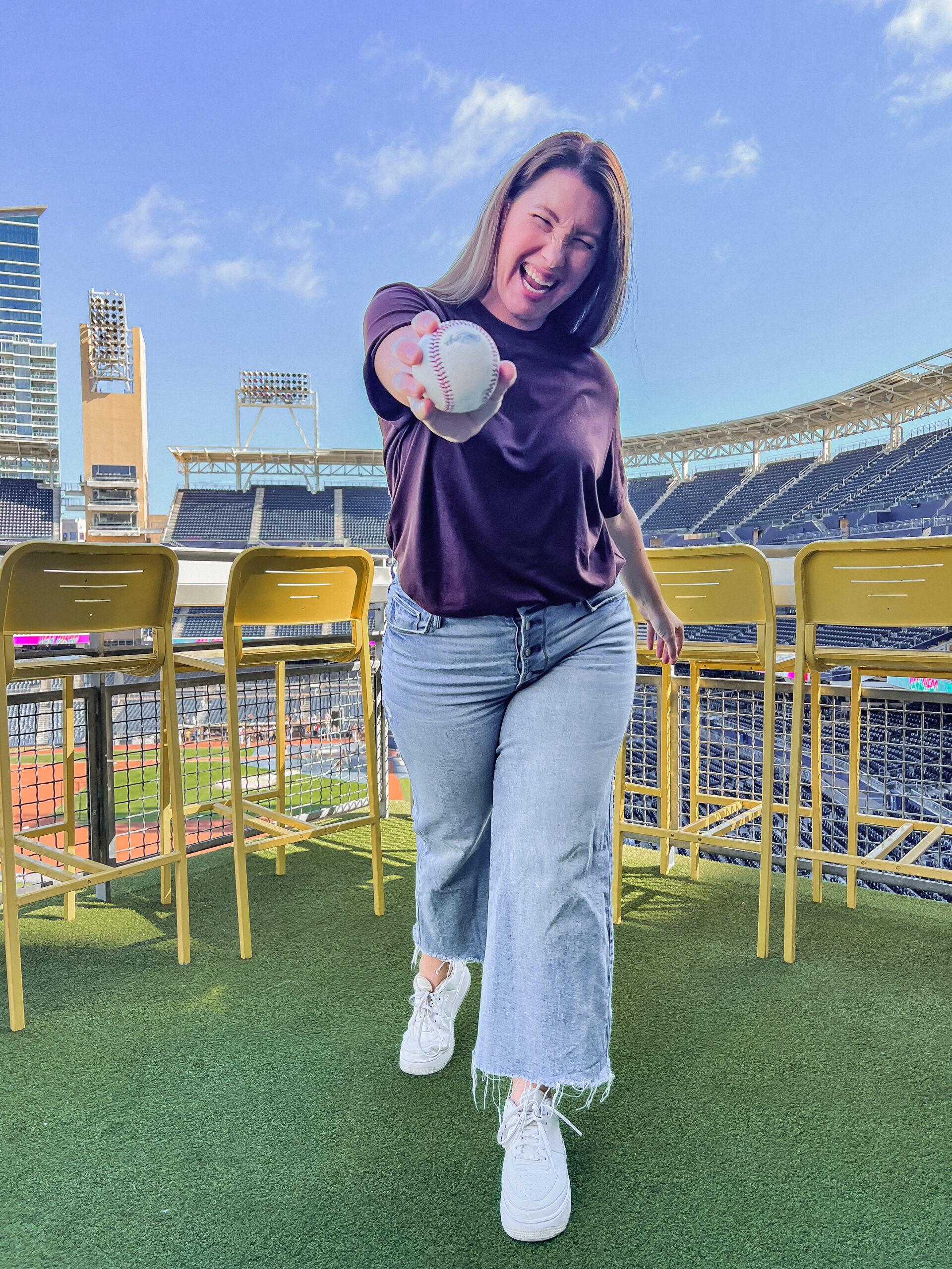 woman in jeans and blouse at a baseball game