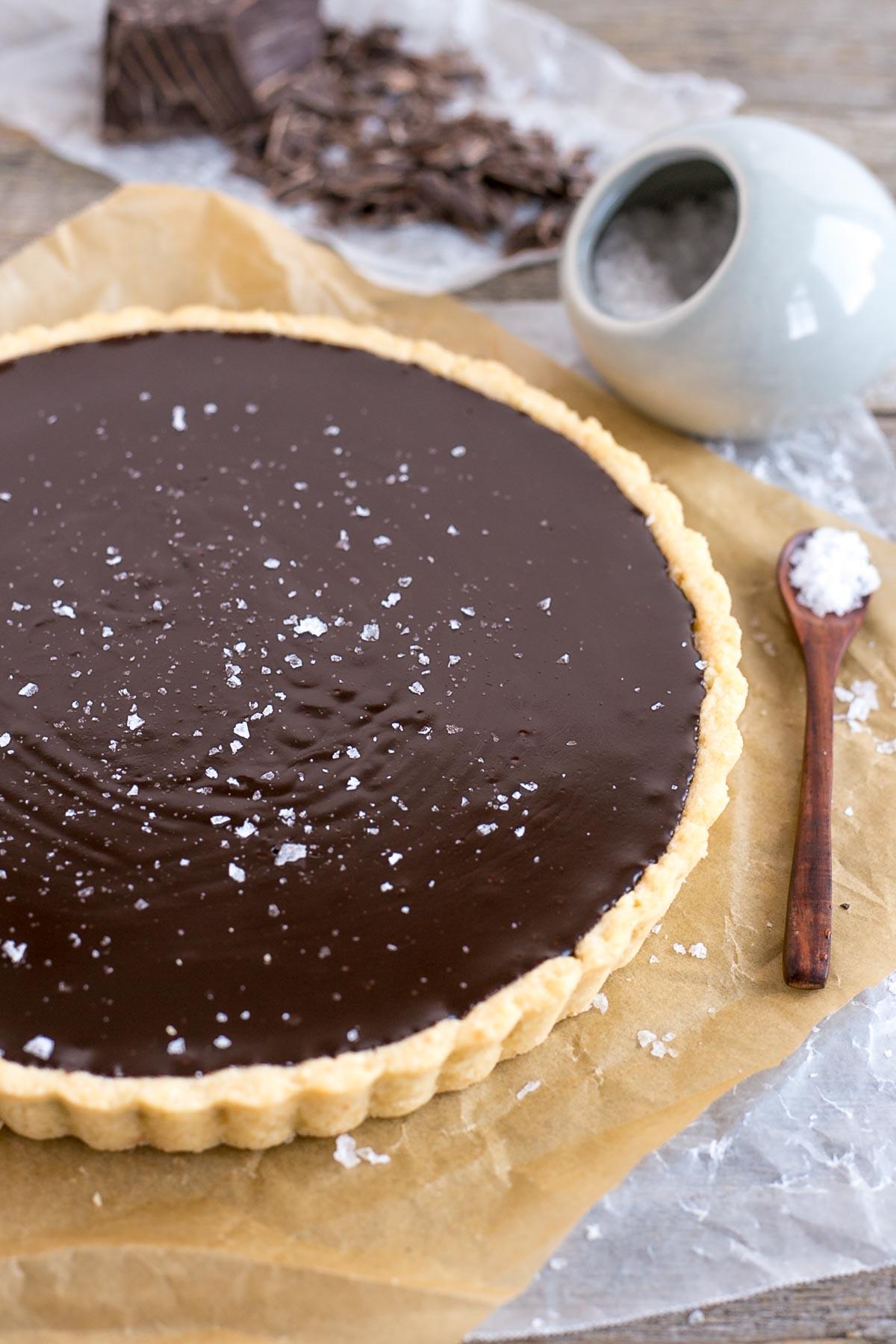 Close-up of the smooth, dark chocolate ganache filling of the tart, with a subtle sheen, before baking.