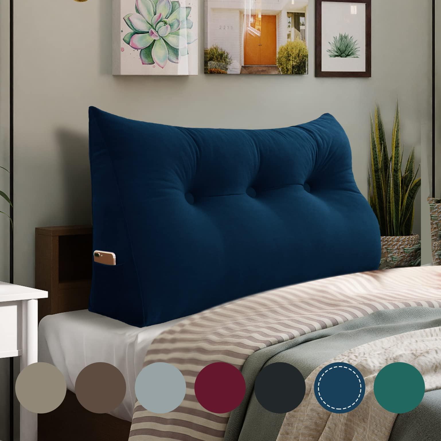 A dorm room with a comfortable setup including pillows and bolsters