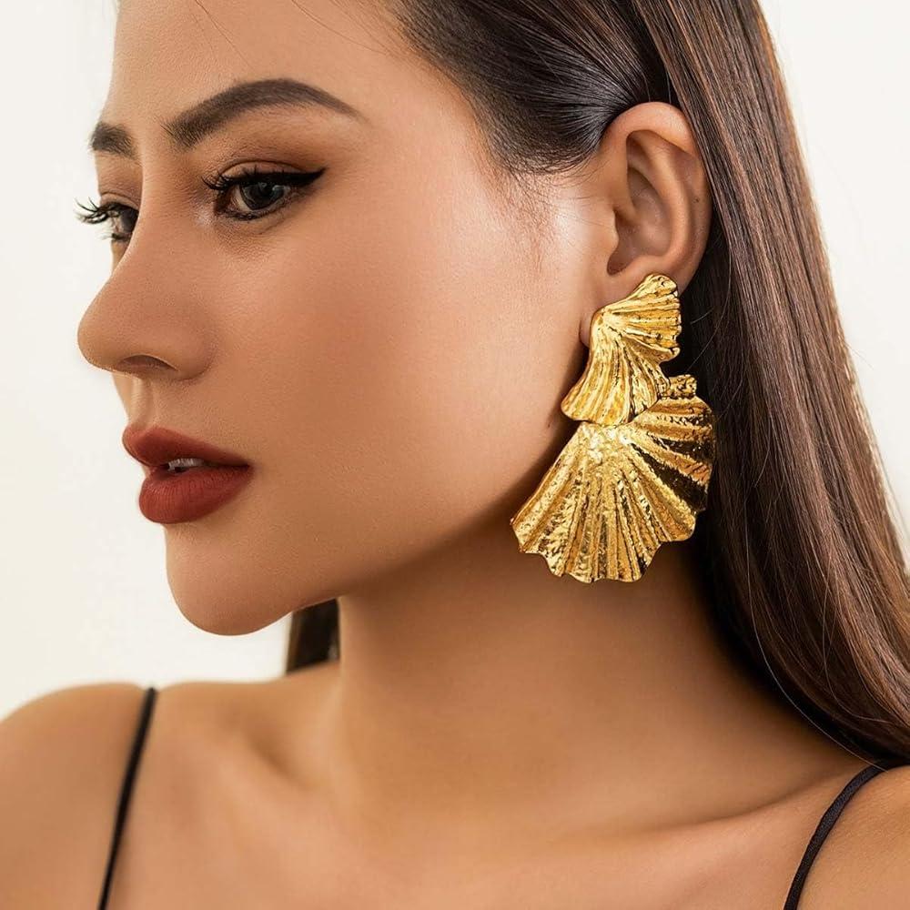 woman wearing statement gold earrings
