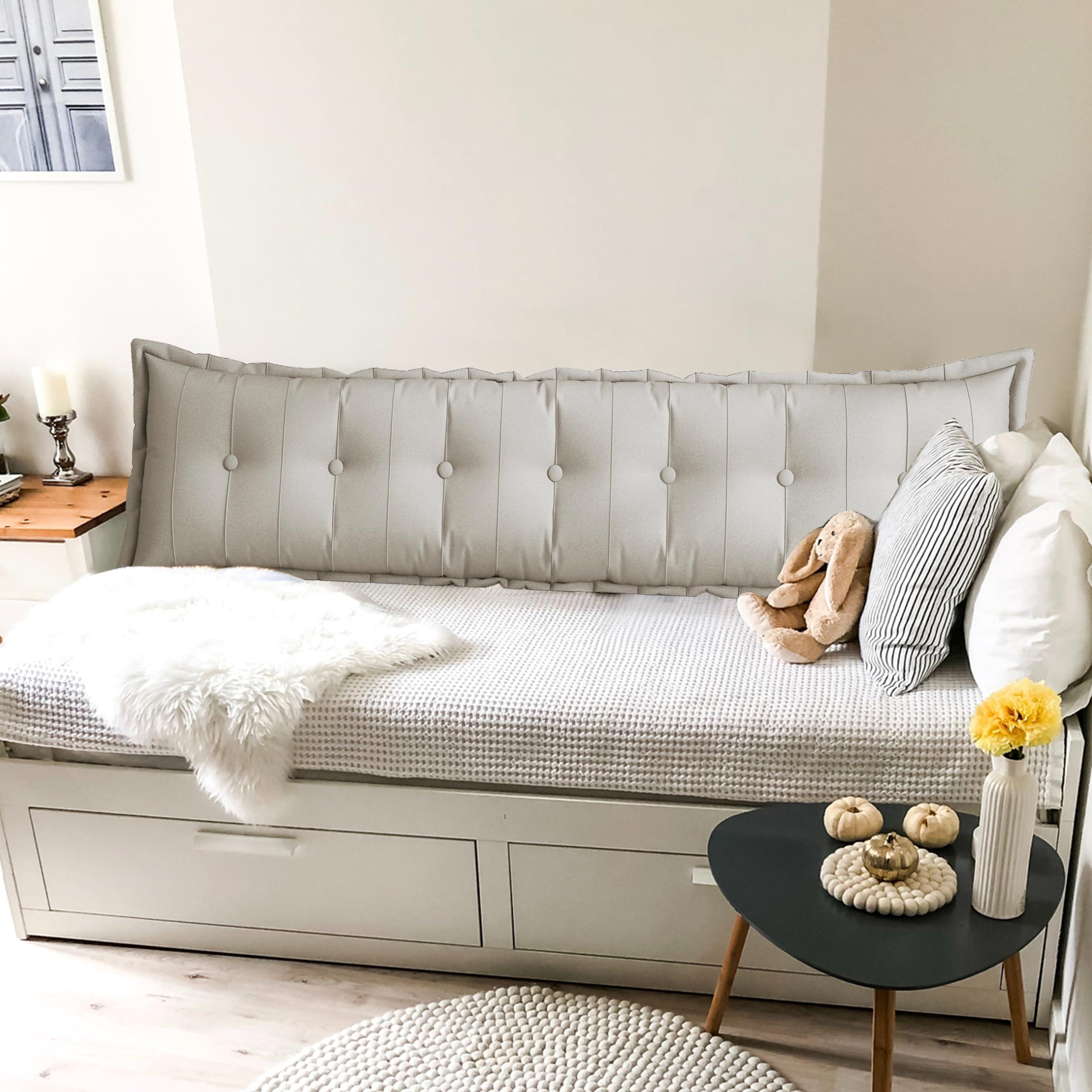 Pillows and bolsters arranged on a dorm room bed