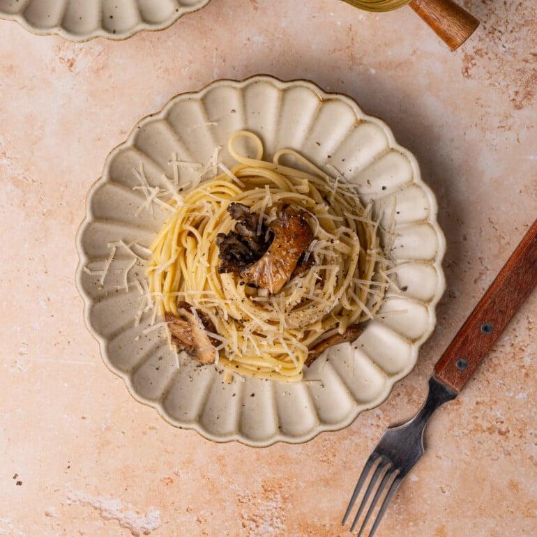 Close-up of truffle oil being drizzled over cooked pasta