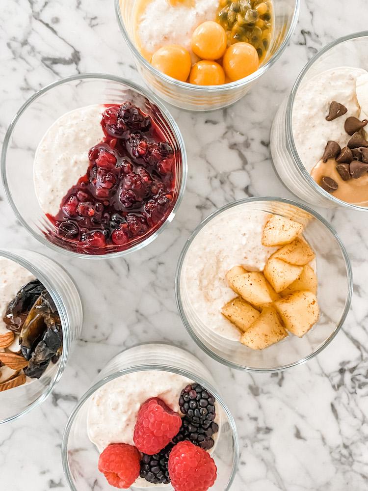various toppings and ingredients for overnight oats arranged on a wooden table