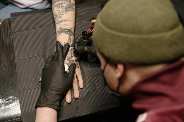 tattoo artist showing their portfolio to a client