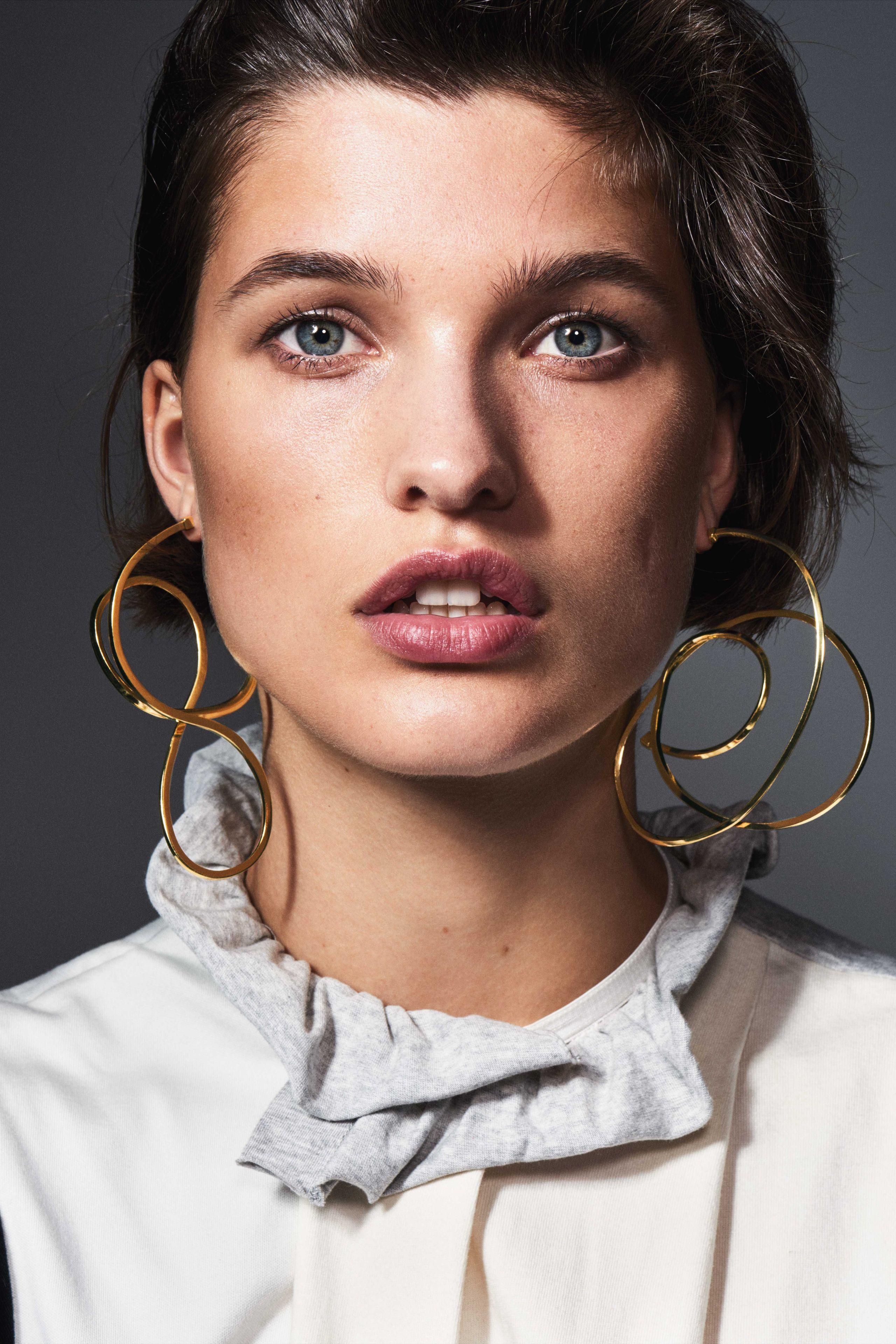 Woman wearing a variety of statement earrings