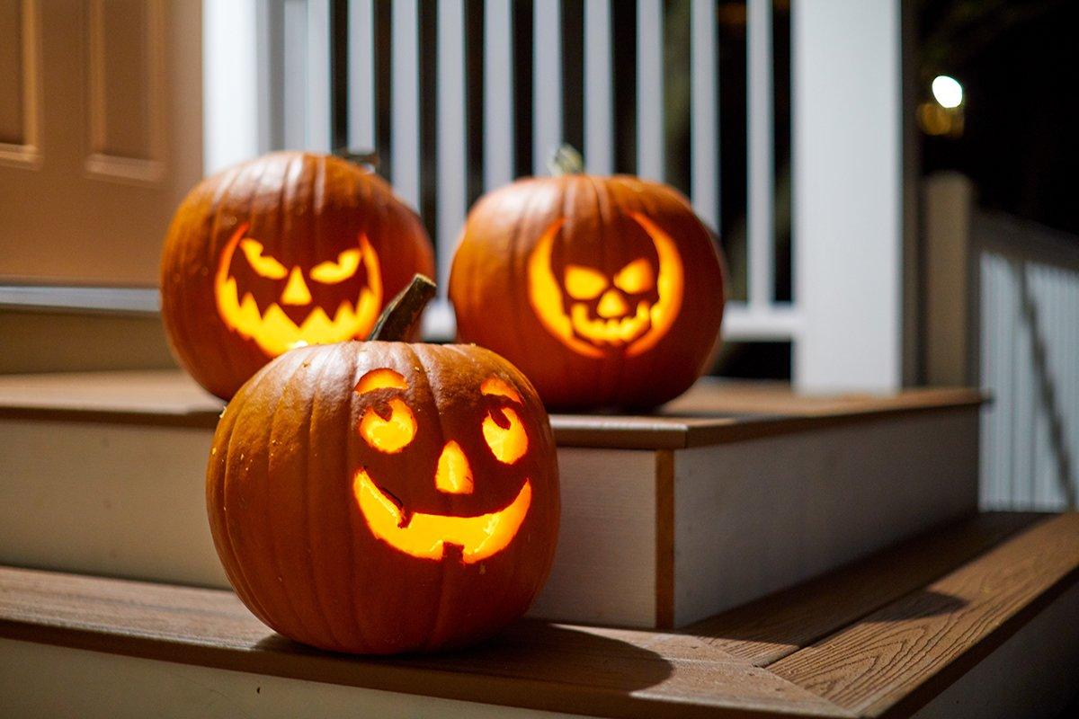A beautifully carved pumpkin with intricate design on a porch