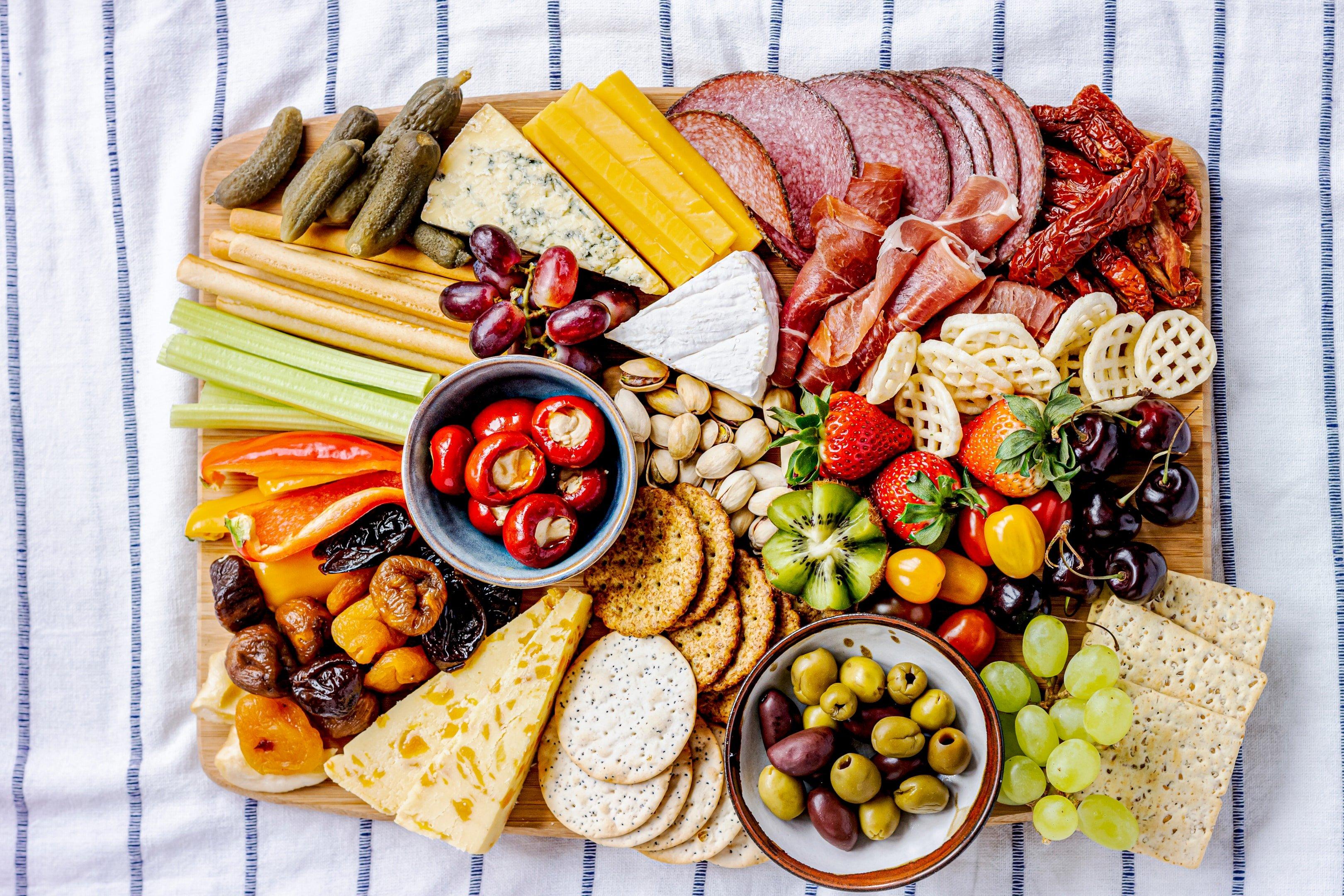 Close-up of diverse charcuterie board elements like artisanal cheeses, cured meats, and colorful fruits