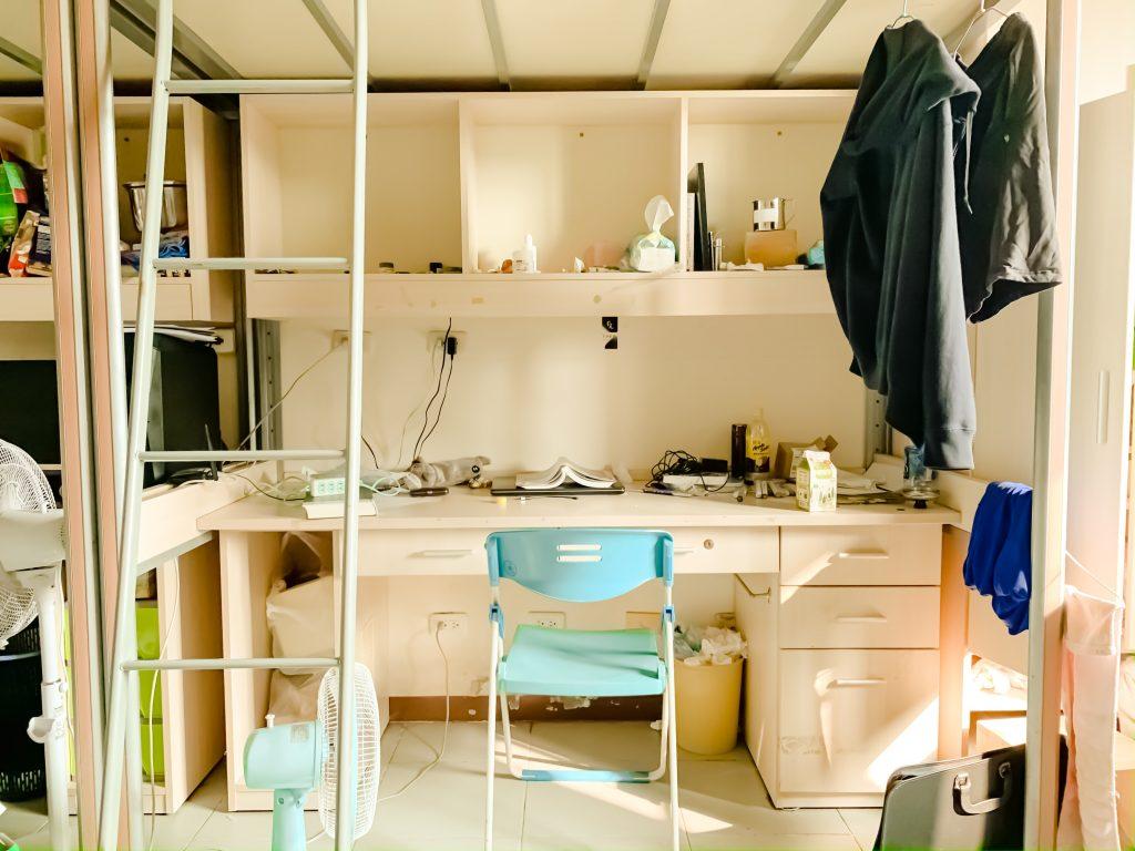 a cluttered dorm room desk needing organization