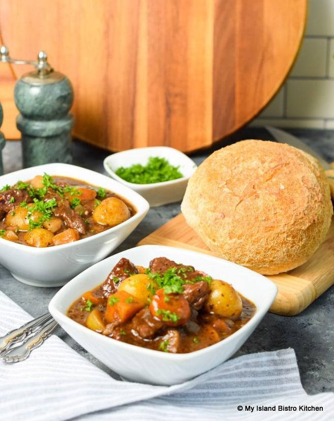 Rustic beef ground stew simmering in a Dutch oven with crusty bread and autumn vegetables