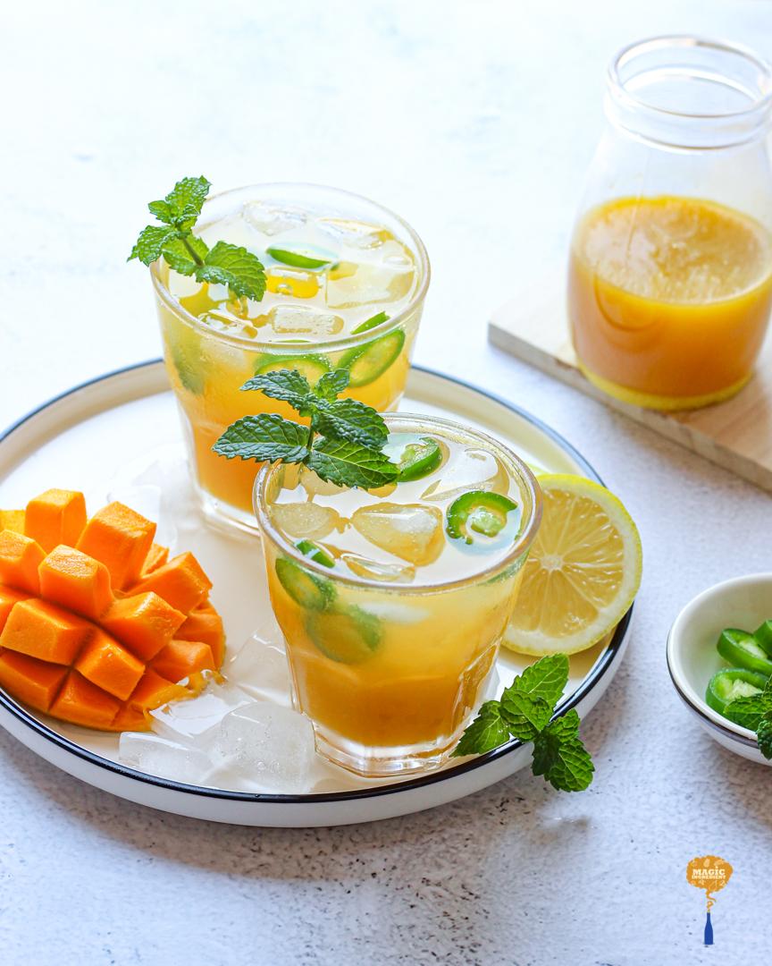 Vibrant mango mint cooler in a festive glass, holiday background