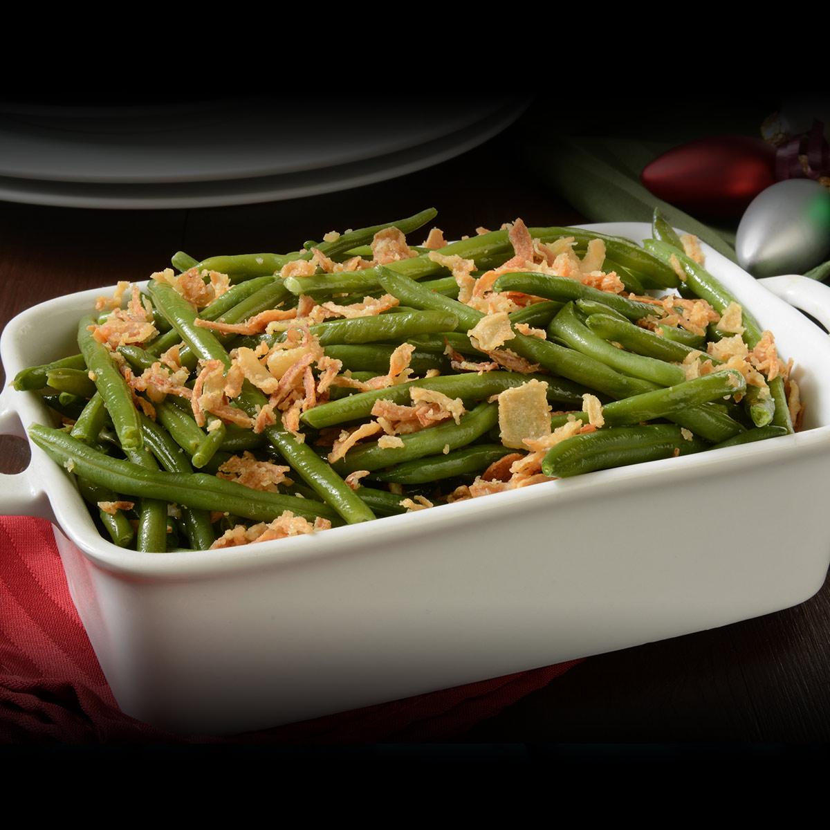 Happy family sharing a holiday meal, green bean casserole prominently displayed on table