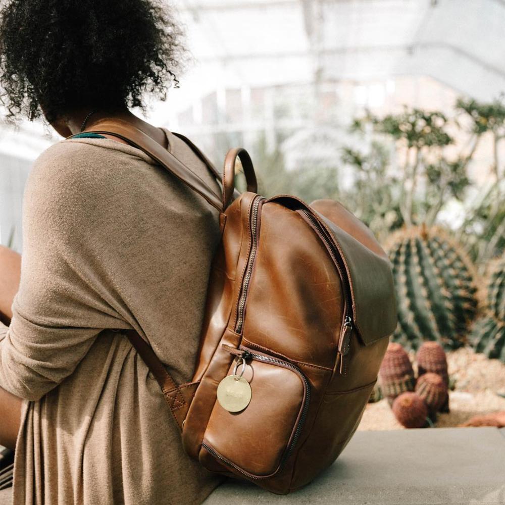woman cleaning and caring for her leather backpack