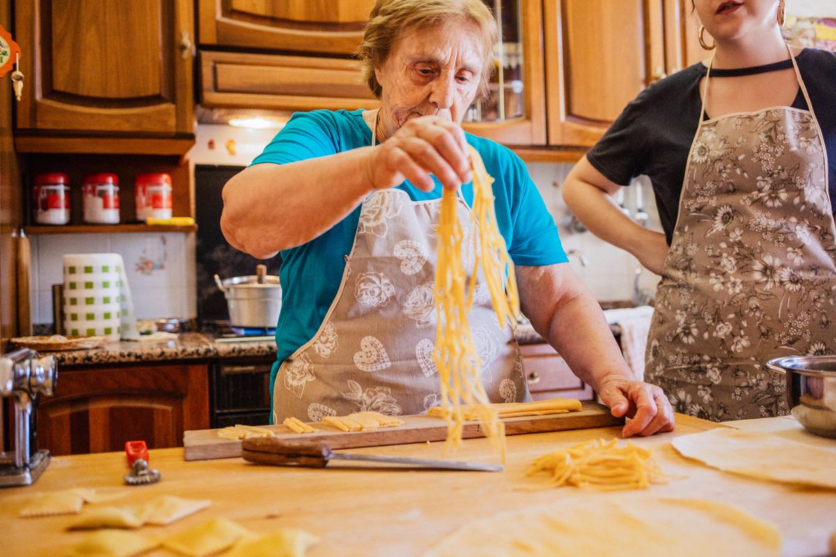 Grandmother cooking pasta in a kitchen