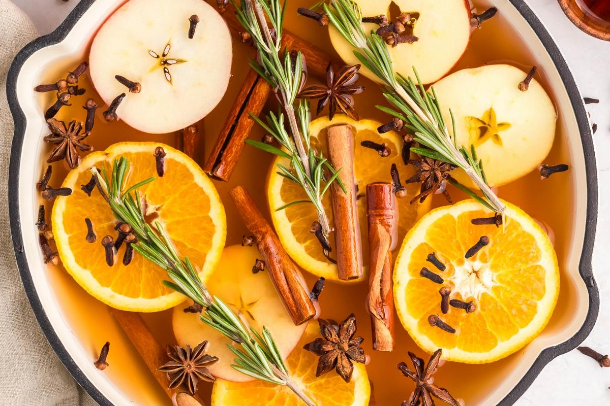 Close-up of orange clove punch simmering gently in a large pot on a stovetop