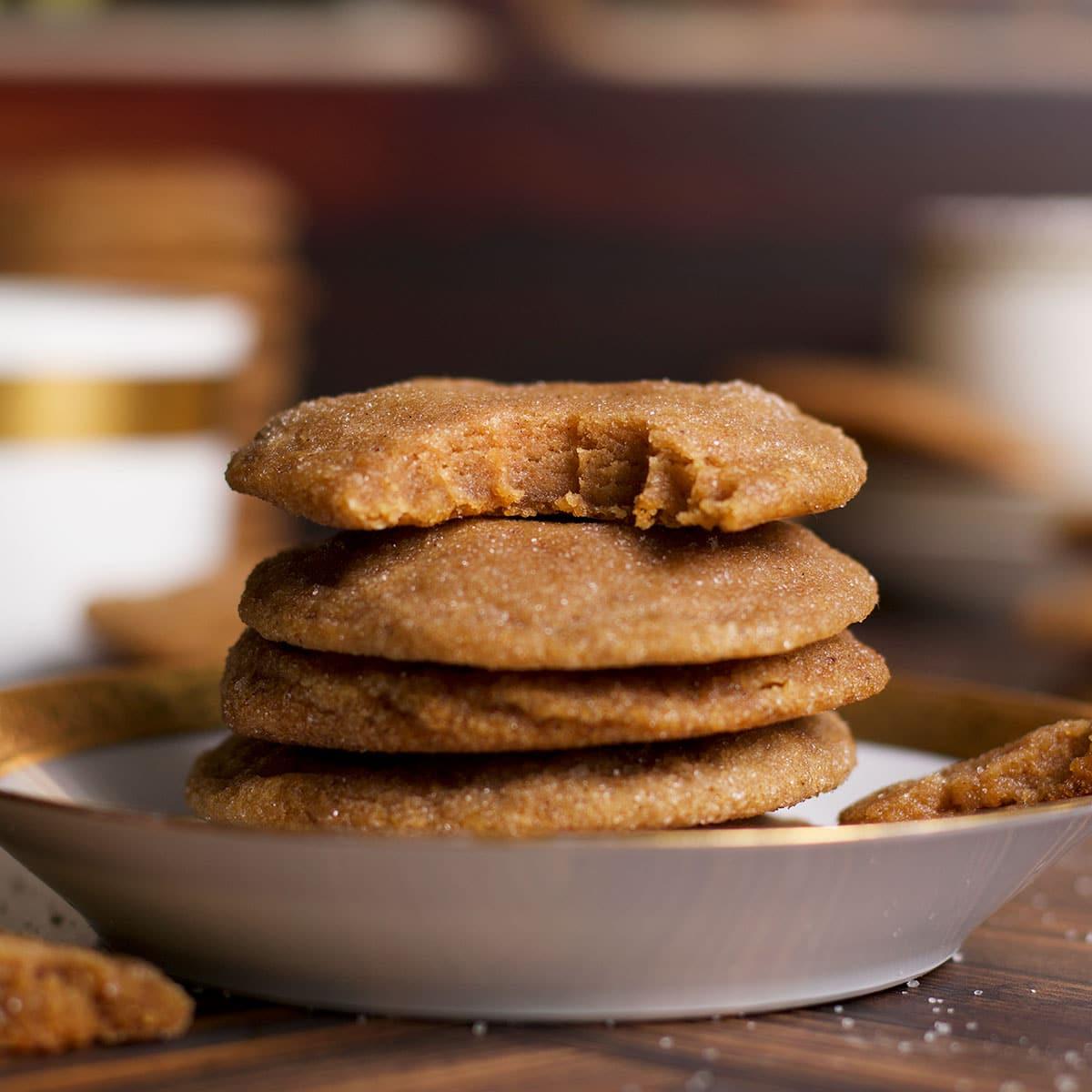 stack of chewy brown butter cookies with a bite taken out, showing gooey interior