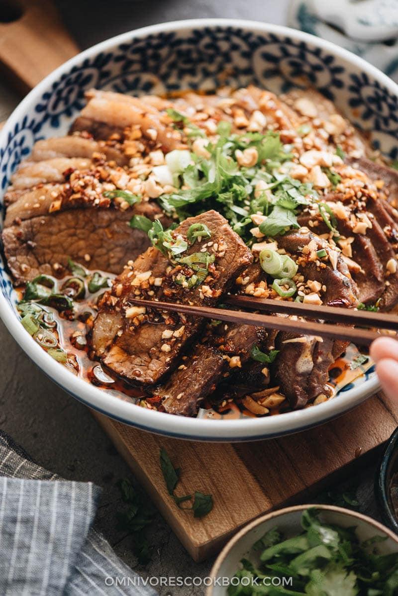 close-up of raw beef slices marinating in chili spices in a bowl