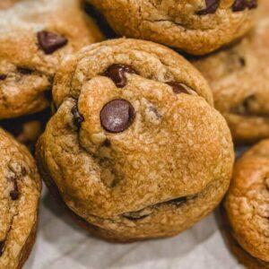 Pile of golden brown butter chocolate chip cookies on a cooling rack, close up