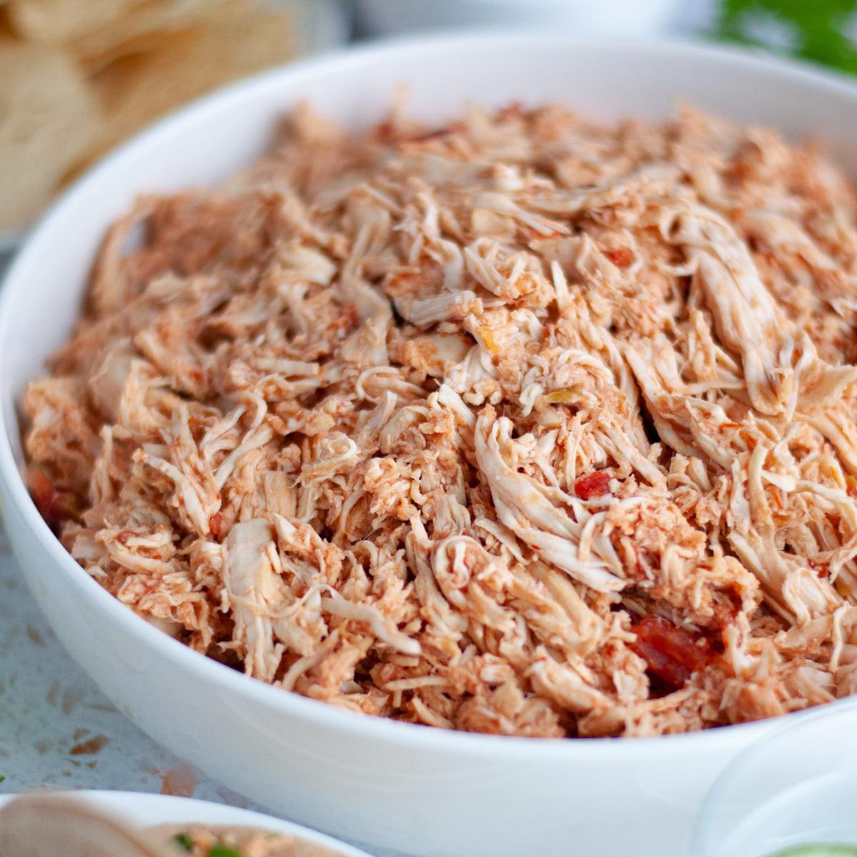 Slow cooker filled with shredded salsa chicken, steam rising, close-up