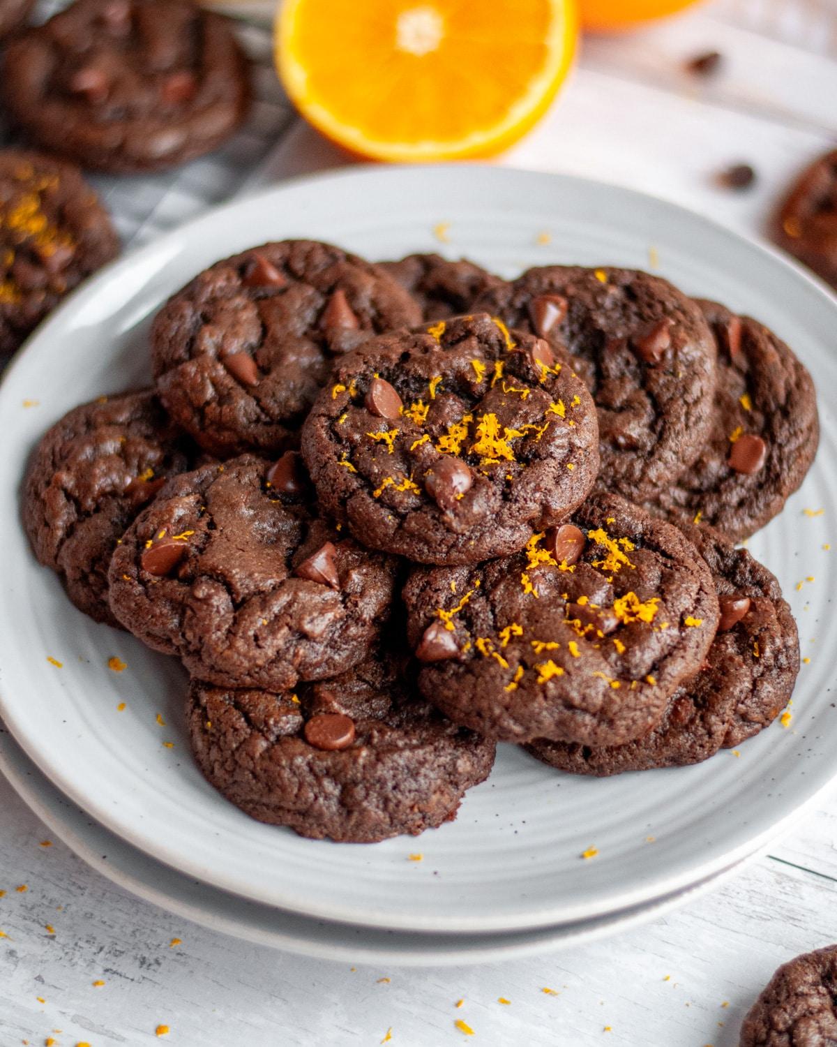 plate of glossy chocolate orange cookies with citrus zest, warm lighting