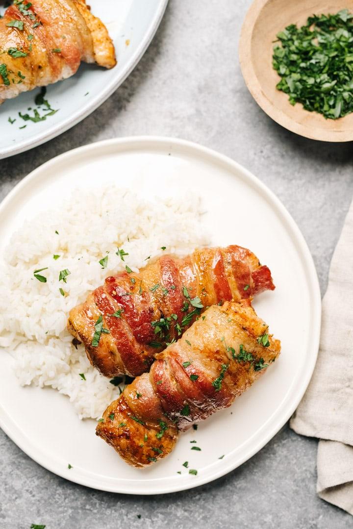 a plate of bacon wrapped keto chicken thighs served with a side of roasted vegetables