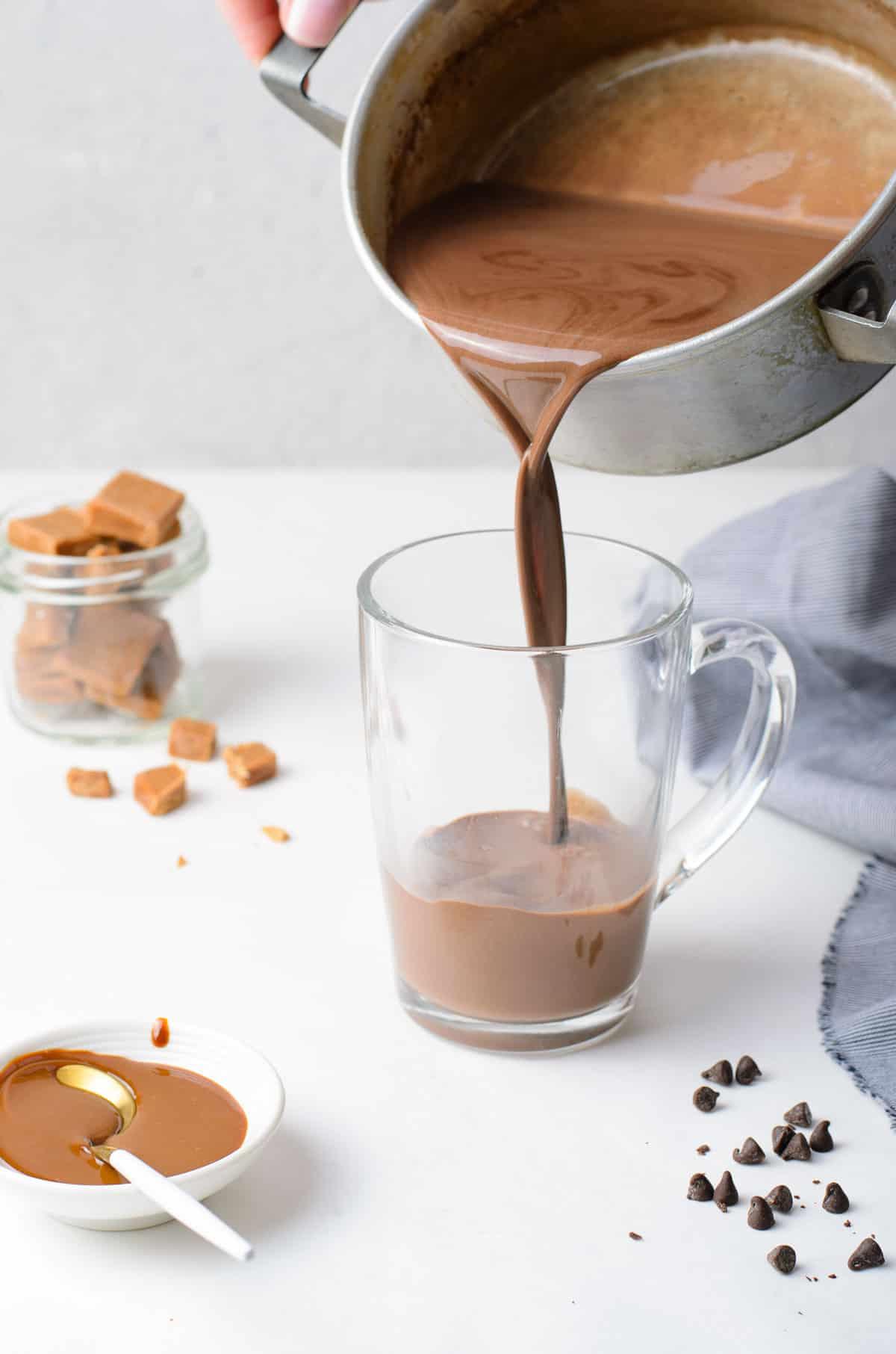 overhead shot of a steaming mug of salted caramel hot chocolate with a spoon