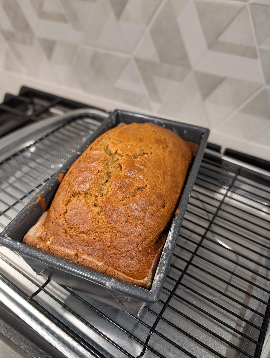 golden brown loaf of pumpkin bread cooling on a wire rack