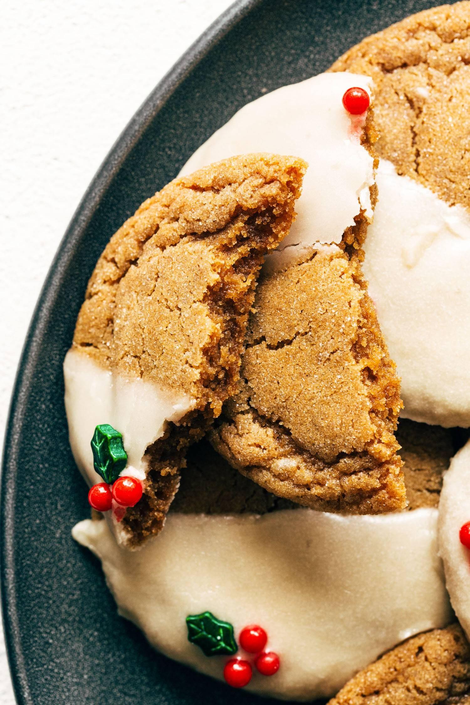Close-up shot of a hand drizzling sweet glaze over a freshly baked ginger cookie