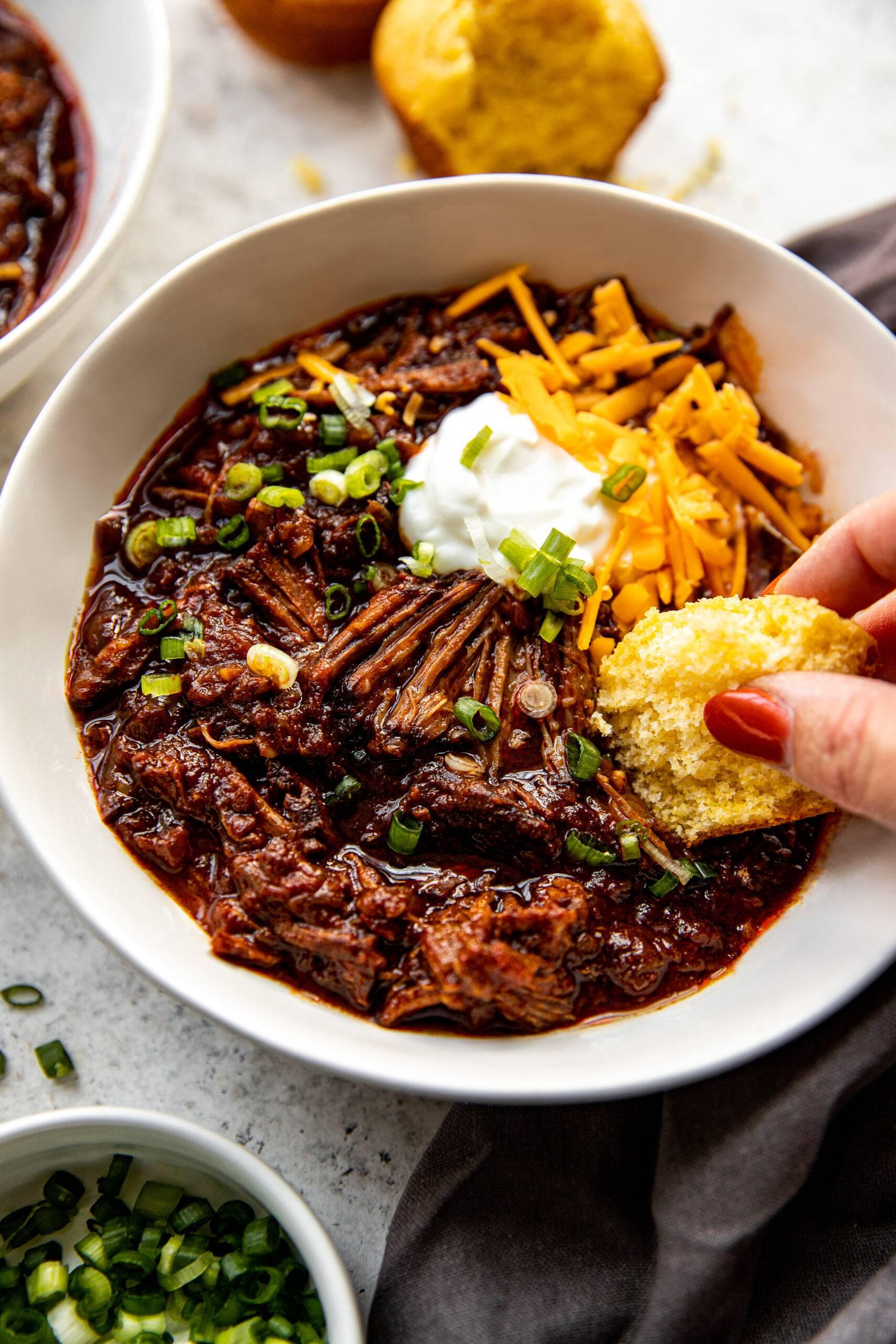 Tender, slow-cooked chili-pepper beef roast shredded with fork, rich sauce