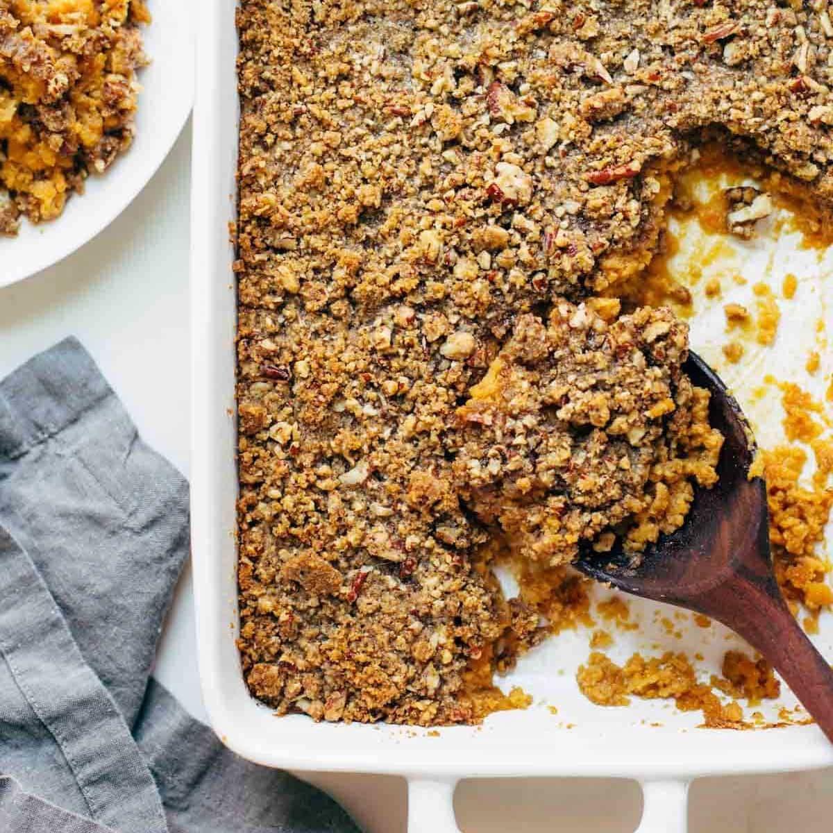 close-up shot of a spoonful of sweet potato casserole showing the creamy base and crunchy streusel topping