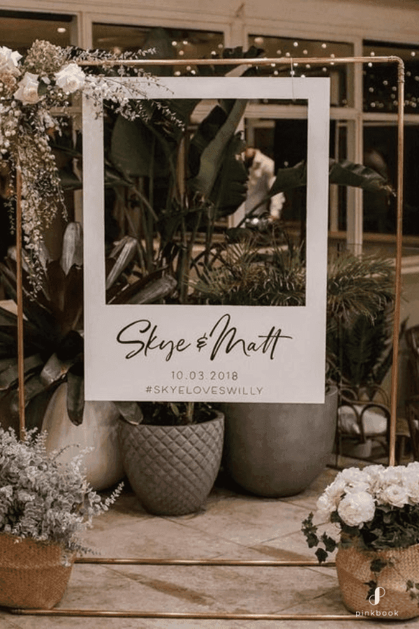 DIY photo booth backdrop with props, guests taking pictures in a photo booth