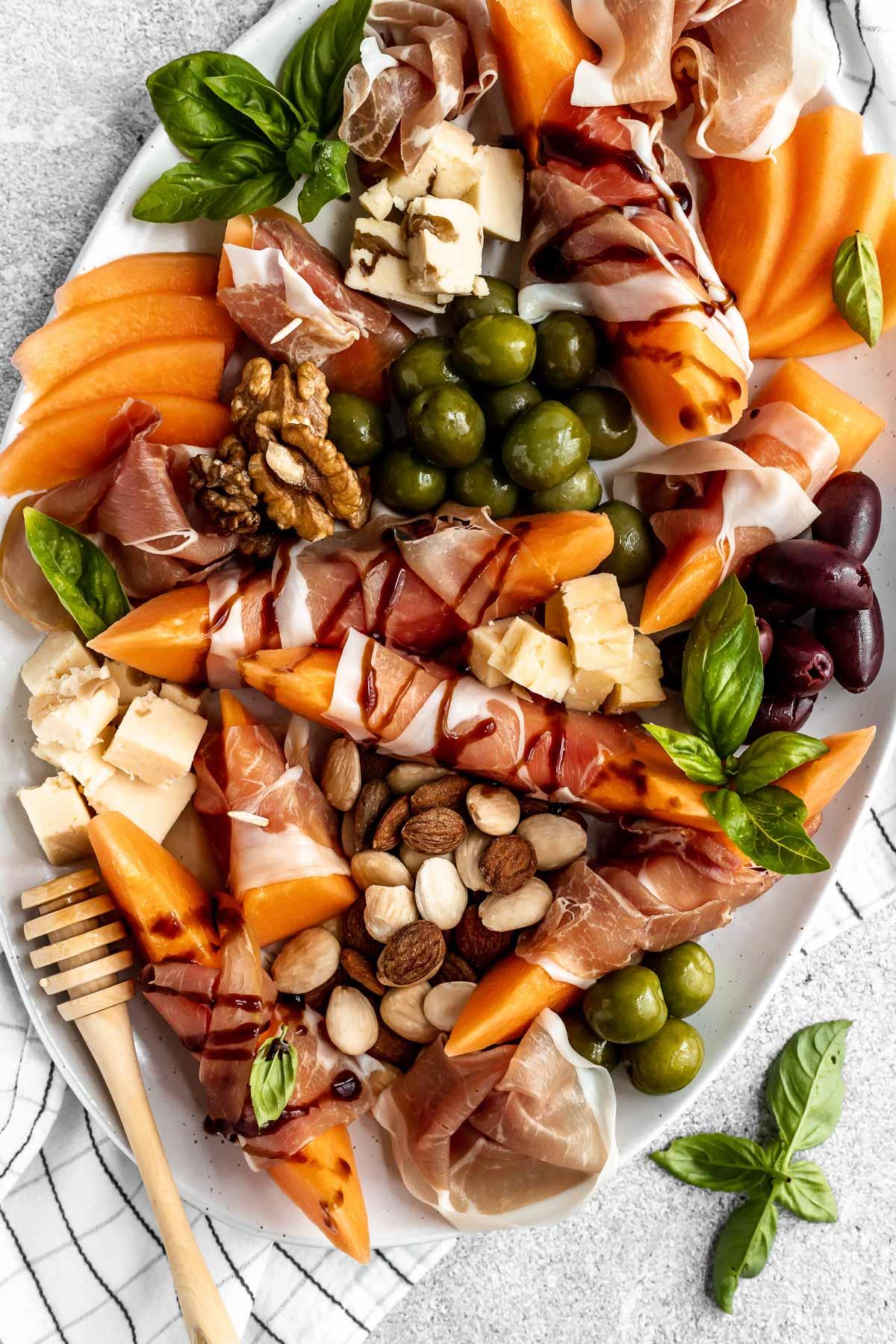 close up of prosciutto wrapped melon bites on a platter