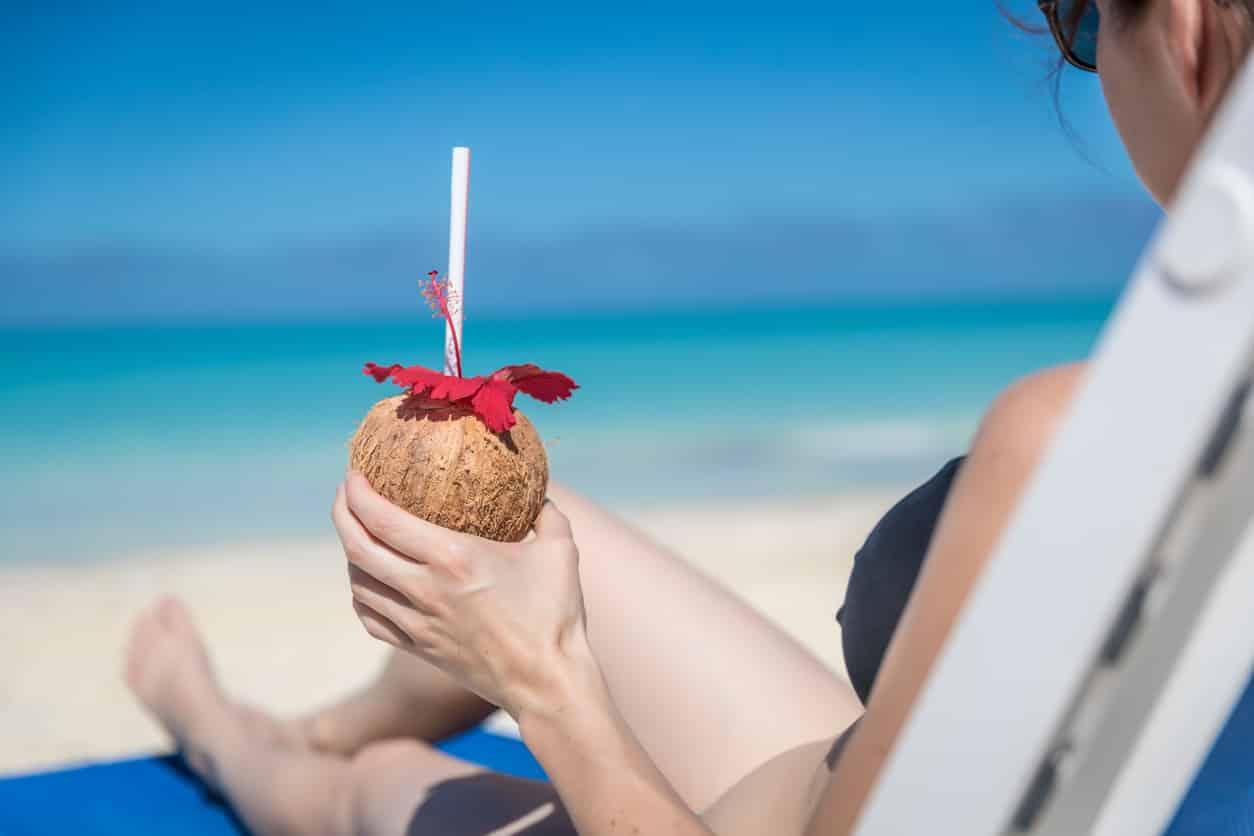 woman relaxing on a beach with a cocktail